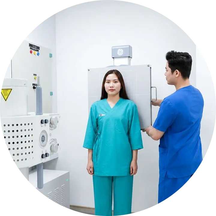 Kỹ thuật viên hướng dẫn khách hàng chuẩn bị chụp X-quang tại TOMEC